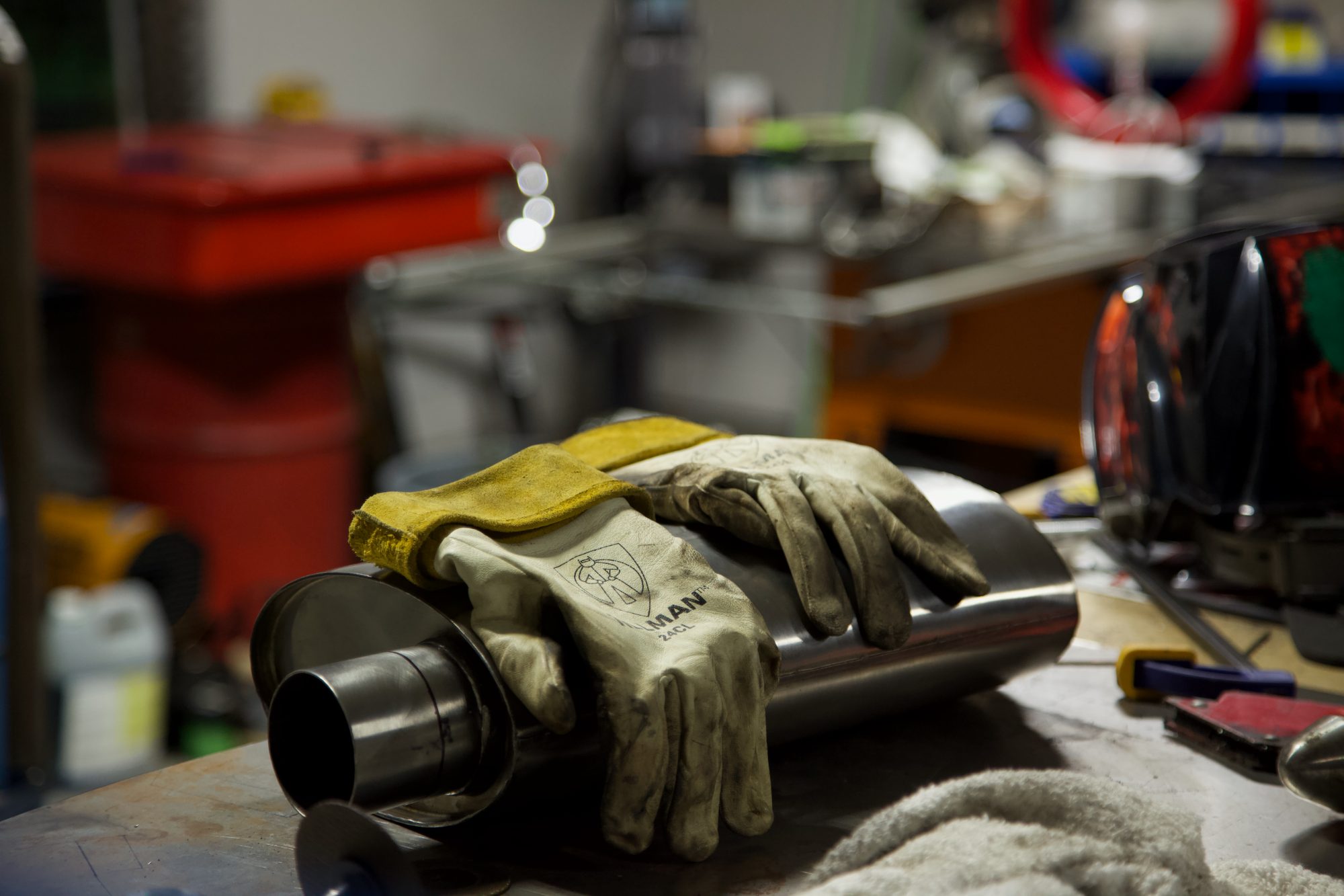 Welding gloves on a muffler